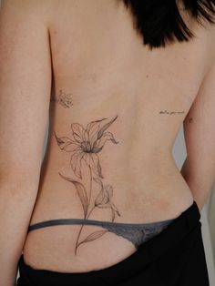 a woman with a flower tattoo on her back and the bottom part of her stomach