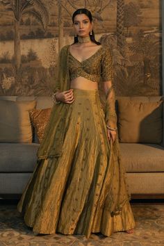 Moss green half sleeve padded blouse with antique gold cutdana, zardozi embroidery in scallop pattern. Paired with embroidered attached cancan lehenga and dupatta. 
Components: 3
Pattern: Embroidery
Type Of Work: Cutdana, zardozi, scallop
Neckline: Scallop V neck
Sleeve Type: Half sleeves
Fabric: Blouse and Lehenga: Tissue Silk, Dupatta: Net
Color: Green
Other Details: 
Model height: 5 ft 8 inches, wearing size XS
Lehenga:
Attached cancan
Length: 45 inches
Blouse:
Padded
Inverted V hem
Back tass Tissue Lehnga Design, Jewellery With Wine Colour Lehenga, Half Sleeves Blouse Designs Indian, Tissue Silk Lehenga Designs, Tissue Lehanga Design, Cheap Lehenga, Traditional Lehenga Blouse Designs, Tissue Lehenga Designs, Tissue Fabric Lehenga