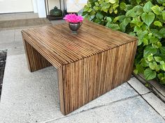 a wooden table with a pink flower on top