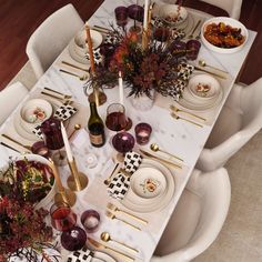 the table is set with white dishes and place settings