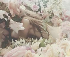 a woman laying in flowers with her eyes closed