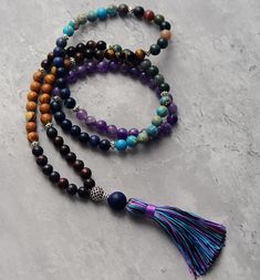 Mala Chakra Our Mala Chakra has arrived to harmonize all your chakras, elevate your energy, and fortify your innate spiritual talents. With 108 mala beads, each selected to correspond to and connect with one of the seven chakras, you can experience the energy flow from stones like amethyst, tiger's eye, jasper, onyx, agate, and wood. Brings a lapiz guru bead. This powerful mala meditation necklace is composed of an abundance of healing gemstones. Wear it to cleanse your chakras and align your bo Jasper And Amethyst, Mala Bead Necklace, Beads Mala, Bracelet Apple Watch, Tiger Eye Jewelry, Rose Quartz Jewelry, Jasper Jewelry, 108 Mala Beads, Chakra Necklace