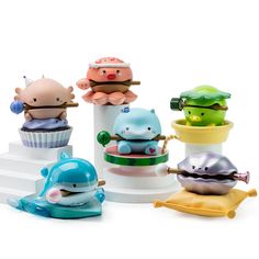 small toy animals sitting on top of cupcakes in the shape of sea creatures