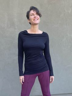 women's plant based rayon jersey long sleeve black top with slight cowl neck and side ruching #color_black Versatile Long Sleeve Elastane Top, Versatile Black Ruched Tops, Ruched Tops For Layering In Fall, Fall Ruched Tops For Layering, Ruched Long Sleeve Top For Fall, Versatile Long Sleeve Top With Thumbholes For Fall, Ruched Fitted Long Sleeve Top For Fall, Stretch Ruched Tops For Fall, Fitted Foldover Long Sleeve Top For Fall