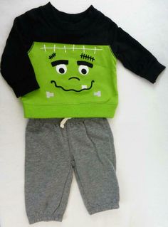 This Newborn size two-piece set is what every little monster needs. The long sleeve top is black with a green applique Frankenstein monster face, ribbed cuffs, neckline and hem. The grey gray pants have cinched cuffs on the bottom and no-pinch elastic waistband. The top is about 10 ¼” and the sleeves are about 7 ¼” from the shoulder to the cuff; the pants measure about 10 ¾” from the waistband to the hem. This costume is for Newborns (up to 21 ½”, 6 – 9 lb); it is new and in excellent condition. Monster Shirt, Frankenstein Monster, Monster Face, Frankenstein's Monster, Pants Green, Theatre Costumes, Green Monsters, Halloween Monster, Gray Pants