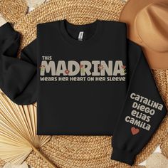 This cozy and stylish sweatshirt features the word Madrina on the front, showcasing your role as a godmother. The personalized touch comes with the option to add your godchild's name on the sleeve, making it a unique and thoughtful gift. The sweatshirt is made from high-quality materials to ensure maximum comfort and durability. Get ready to show off your godmother status in style with our Madrina sweatshirt. PLEASE BE SURE TO READ THE ENTIRE LISTING AS WELL AS THE SHOP FAQ'S AND POLICIES. If yo Christmas Day, Godmother, Heart On, Pullover Sweatshirt, San Jose, Favorite Outfit, No Response, Gender Neutral, Loose Fitting