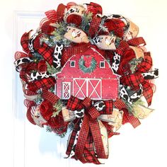 a red and black wreath with a barn on it