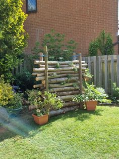 a wooden fence made out of logs and plants