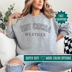 It's cozy season with our Hot Cocoa Weather Crewneck! Perfect for chilly days and sipping on your favorite hot cocoa, this sweatshirt is a fall essential. Ideal for coffee weather too, it's designed to keep you warm and stylish throughout the season. Whether you're lounging at home or out and about, this women's sweatshirt adds a touch of seasonal charm to your wardrobe. Grab your cozy fall sweatshirt today and stay snug all season long! Production Time: 🤍 1-3 Business Days Shipping Time: 🤍 2- Cozy Heather Grey Crew Neck Sweater, Super Soft Relaxed Fit Sweater For Winter, Cozy Graphic Print Sweater For Winter, Cozy Graphic Print Winter Sweater, Cozy Winter Sweatshirt For Leisure, Cozy Winter Leisure Sweatshirt, Heather Grey Cozy Sweater With Relaxed Fit, Super Soft Cotton Tops With Cozy Fit, Cozy Heather Grey Sweater With Relaxed Fit