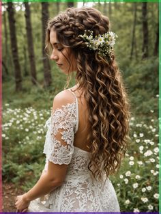 a woman with long curly hair wearing a white dress in the middle of a forest