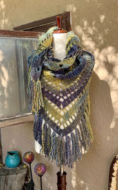 a multicolored shawl hanging from a window sill