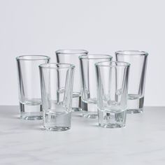 six clear glass tumblers lined up in a row