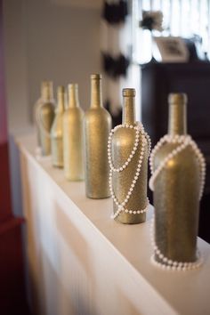 several bottles with pearls on them sitting on a shelf