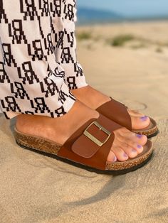 Adorn your feet with effortless style when you don this buckle slide that is ideal for your warm weather attire. Slip-on / buckle closure Man-made upper Cushioned footbed cushioned EVA sole Beach Sandals With Tang Buckle And Slip-on Design, Casual Round Toe Slides With Tang Buckle, Casual Slides With Tang Buckle And Round Toe, Casual Slip-on Slides With Tang Buckle, Casual Tang Buckle Slip-on Slides, Spring Slip-on Footbed Sandals With Tang Buckle, Beach Slip-on Footbed Sandals With Buckle Closure, Vacation Leather Footbed Sandals With Flat Heel, Casual Summer Footbed Sandals With Tang Buckle