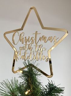 a gold christmas ornament hanging from a tree