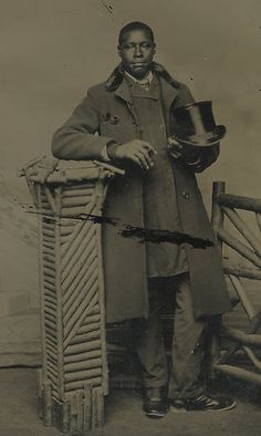 an old black and white photo of a man holding a hat