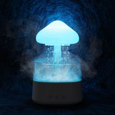 a blue mushroom shaped light is on top of a glass container with steam coming out of it