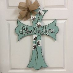 a door hanger with a cross decorated with flowers and the words, bess out home