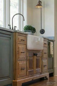 a kitchen with an island sink and wooden cabinets in the center, along with a hanging potted plant