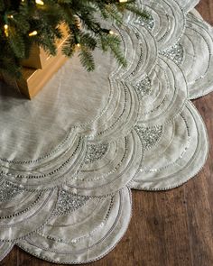 a small christmas tree on top of a wooden floor next to two placemats