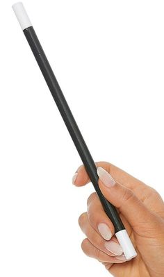 a hand holding a black and white object in it's left hand, with the top part of its stick sticking out