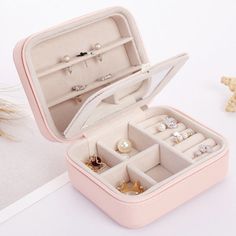 an open pink jewelry box on a table