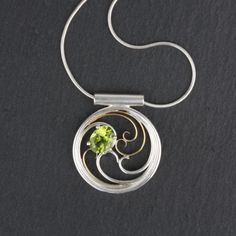 Elegant filigree swirls around a sparkling Peridot. Perfect gift for any occasion - this stunning necklace is as unique as the woman who wears it, and is sure to make her feel beautiful and loved. At 1" diameter, this necklace is small enough to wear every day with a simple blouse or top; or, pair it with a little black dress or a flirty v-neck for a night out. Peridot is the birthstone for August, and is also the traditional stone for celebrating a 16th wedding anniversary. Materials: Sterling Elegant Swirl Necklace For Gifts, Elegant Swirl Necklace For Gift, Elegant Sterling Silver Swirl Necklace, Green Sterling Silver Fusion Necklace, Elegant Spiral Filigree Jewelry, Elegant Peridot Necklaces For Wedding, Elegant Green Spiral Jewelry, Waves Necklace, 16th Wedding Anniversary