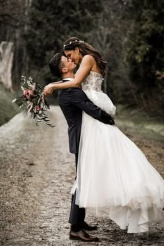 a bride and groom kissing on the road