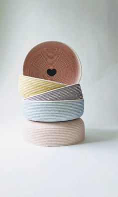 three rolls of woven fabric stacked on top of each other with a heart in the middle