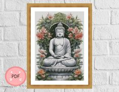 a buddha statue sitting in front of a brick wall with flowers and leaves around it