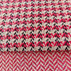 red and white checkered fabric with black dots on it's edges, close up