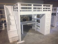 a white loft bed with drawers and desk in the middle of it, next to other bunk beds