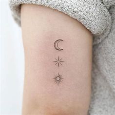 a woman's arm with a small sun and moon tattoo on the left side