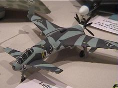 a model fighter jet sitting on top of a table next to other toys and papers