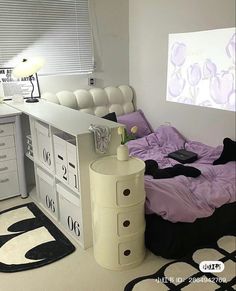 a bed room with a neatly made bed next to a desk and drawers on the wall