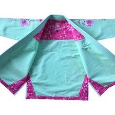 a blue and pink japanese kimono with flowers on it's sleeves, sitting on a white surface