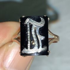 Stunning Art Deco 1920's black onyx and 9ct gold silver initial E ring. Here we have an Art Deco ring with a silver initial E  set onto black onyx, and set in 9ct gold, and with a 9ct gold shank, marked 9ct gold inside the gold shank. The silver set initial is lightly engraved, and is in an old English script. The ring is in a good antique condition,  and the onyx is firmly held in place by four gold claws, and the gold band is good and strong. A great statement or stand alone ring. Measures:  Ring size:  U.K.  P 1/2.     U.S.  inbetween 7 3/4 and 8                      Ring face:  Width:  1cm x.    Height:  1.4cm                     Weighs:  2.7 grams All weights and measures are approximate. Thank you for looking. Classic Black Initial Ring For Formal Occasions, Black Round Jewelry With Initials, Black Elegant Initial Ring For Anniversary, Elegant Black Initial Ring For Anniversary, Black Initial Ring With Polished Finish As Gift, Gift Black Initial Ring With Polished Finish, Classic Black Round Initial Ring, Symbolic Black Sterling Silver Engraved Ring, Symbolic Black Engraved Sterling Silver Ring