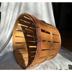 a wooden basket sitting on top of a white sheet