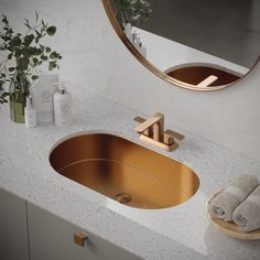 a bathroom sink with gold faucet and mirror