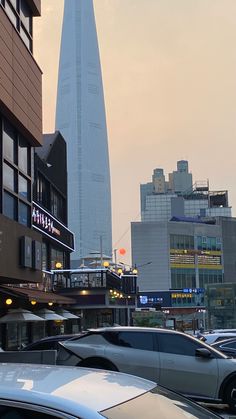 cars are parked in front of a tall building with the shara on it's side