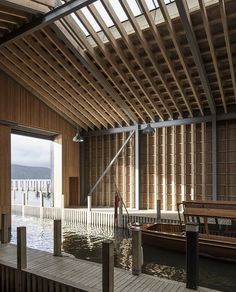 the inside of a boathouse with wooden walls and flooring, along with water