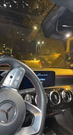 the steering wheel and dashboard of a mercedes c - class coupe car at night time