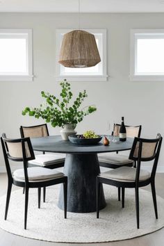 a round dining table with chairs around it