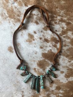 Adjustable genuine leather with faux turquoise shards and faux Navajo pearl beads. Rustic Beaded Turquoise Necklace, Adjustable Beaded Rustic Turquoise Necklace, Bohemian Beaded Leather Jewelry, Adjustable Brown Turquoise Bohemian Necklace, Southwestern Brown Turquoise Necklace With Natural Stones, Handmade Rustic Adjustable Turquoise Necklace, Unique Beaded Leather Jewelry, Handmade Adjustable Southwestern Turquoise Necklace, Handmade Southwestern Adjustable Turquoise Necklace