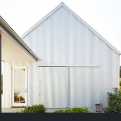 a white house with an open door on the front and side of it's building