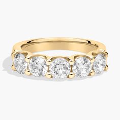 a yellow gold ring with five stones on the side and four diamonds in the middle