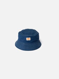 Bucket hat made from organic and recycled cotton. At 80% virgin organic cotton, the tightly woven lightweight denim offers great durability.  Kids grow, but clothes don't. When the hat is outgrown, hand it down. Or trade it in at any Nudie Jeans Repair Shop!     Interested to know more about our Utility Denim? Happy to hear it:  Nudie Jeans Utility Denim is our take on the denim of the best chore coats, dungarees, and carpenters' pants from the 1930s, which utilizes fine, high-twist yarns togeth Pre-washed Cotton 5-panel Hat, Adjustable Pre-washed Bucket Hat, Blue Cotton Wide Brim Hat, Denim Cap For Outdoor Use, Denim Cap For Outdoor, Denim Blue Cotton Hat For Beach, Casual Pre-washed Bucket Hat With Curved Brim, Denim Blue Hat With Curved Brim, Blue Washed Hat With Curved Brim