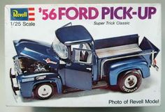 an old model blue truck with the hood open