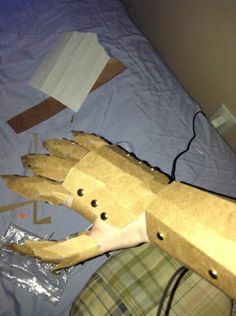 an animal made out of cardboard sitting on top of a bed