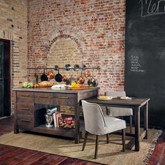 a kitchen with brick walls and an old fashioned table in front of the blackboard